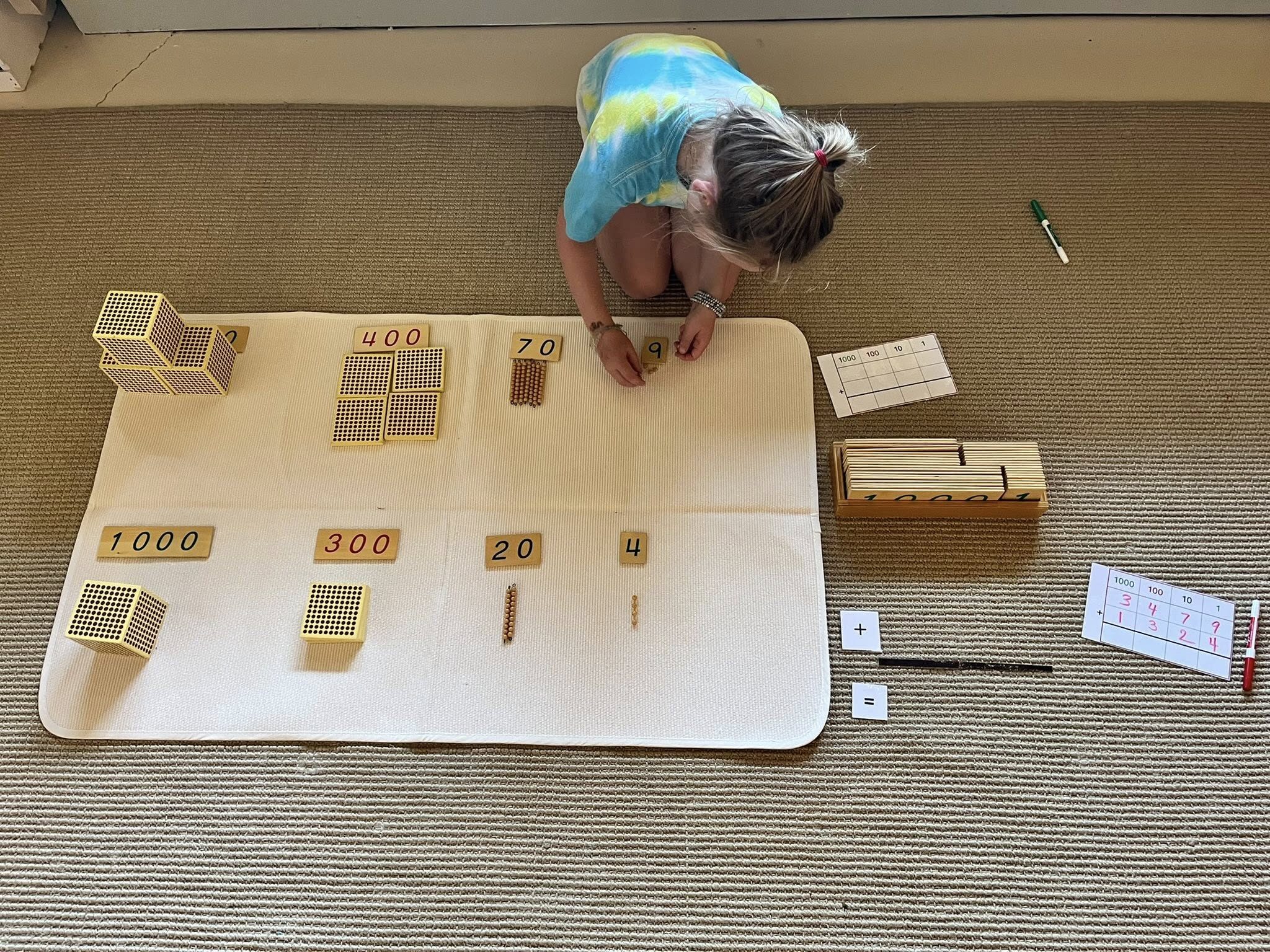 child working on addition with montessori golden bead materials