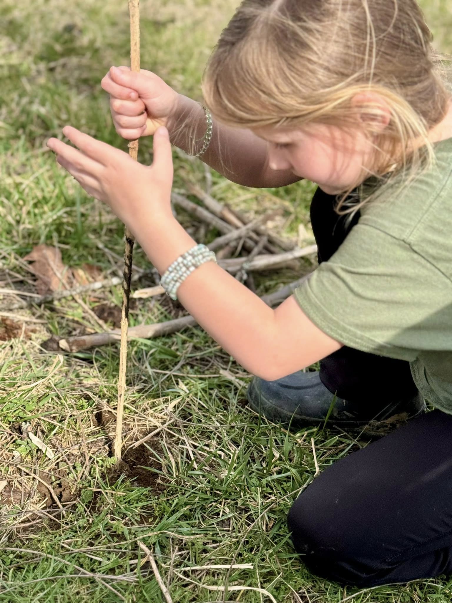 girl beginning to build a shelter with sticks