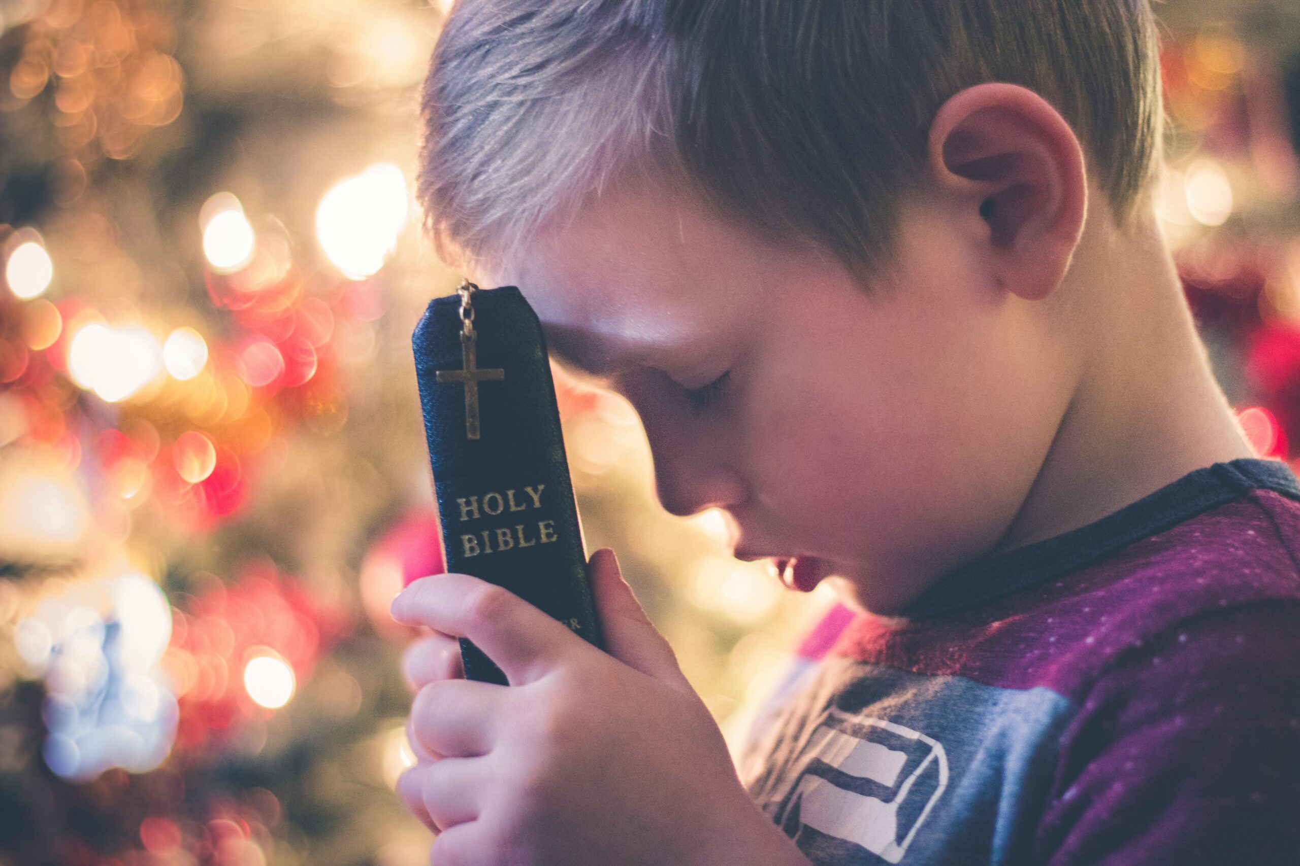 a young boy holding a Bible